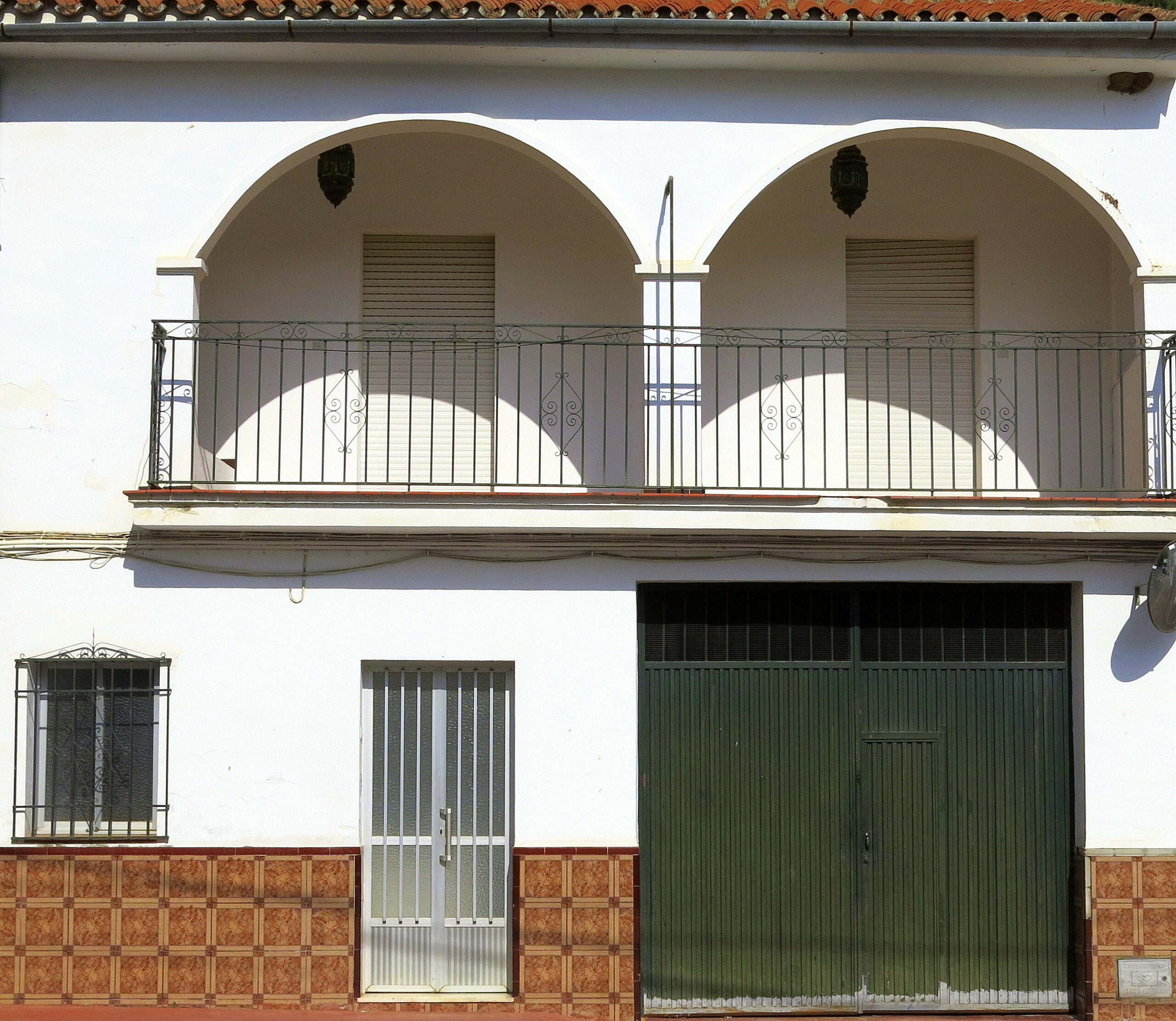 Detalle de una puerta de metal verde en una calle de Benaoján